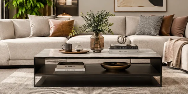 Black metal coffee table styled with books, a vase and a tray in a living room
