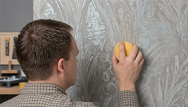 A person using a scoring tool on the wall