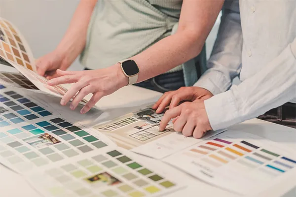 Some people watching different color samples on a table