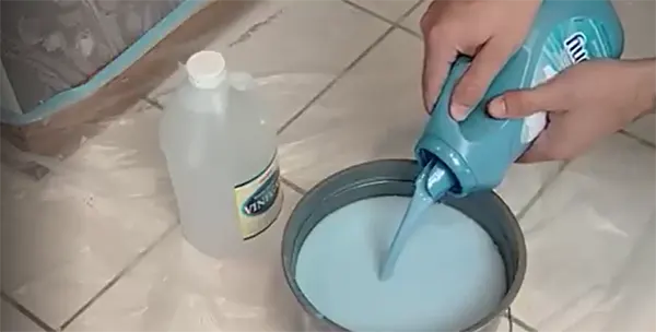 a person’s hand putting a chemical in the bucket